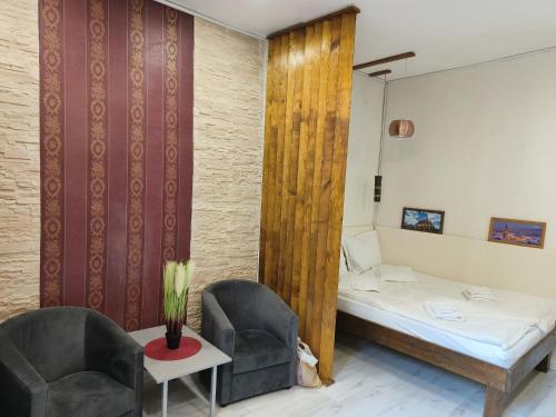 a small room with a bed and two chairs at Cluj Center 3 in Cluj-Napoca