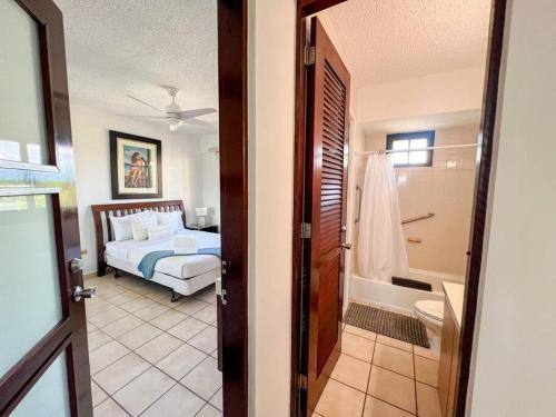 a bedroom with a bed and a bathroom at Crescent Beach Apt Ocean View in Humacao