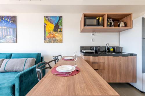 a living room with a wooden table and a kitchen at GO Rio Branco by LikeHome in Porto Alegre