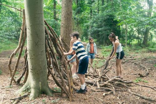 a group of people standing around a tree root structure at Fritton Lake - The Clubhouse in Great Yarmouth