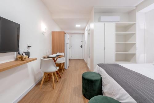 a bedroom with a bed and a table and chairs at Connect by LikeHome in Porto Alegre