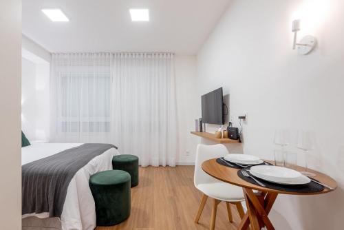 a bedroom with a bed and a table and chairs at Connect by LikeHome in Porto Alegre