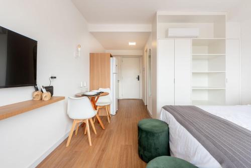 a bedroom with a bed and a table and chairs at Connect by LikeHome in Porto Alegre