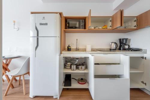 a white refrigerator in a kitchen with a table at Connect by LikeHome in Porto Alegre