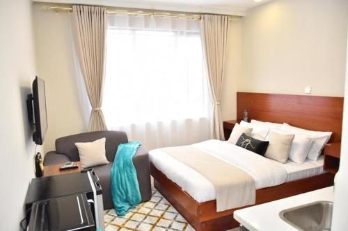 Postel nebo postele na pokoji v ubytování Indesign makumbi Apartment