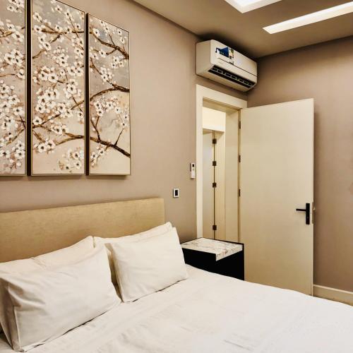 a bedroom with a bed with white pillows at Spacious and Modern Apartment for Rent in Ergah, Riyadh in Riyadh