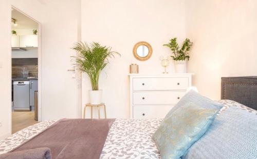 - une chambre avec un lit et une commode ornée de plantes dans l'établissement Duplex Disney, à Chessy