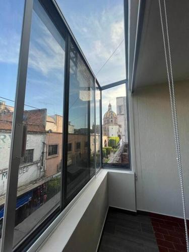 an empty room with large windows in a building at Morelos 67 Apartment in La Piedad Cavadas