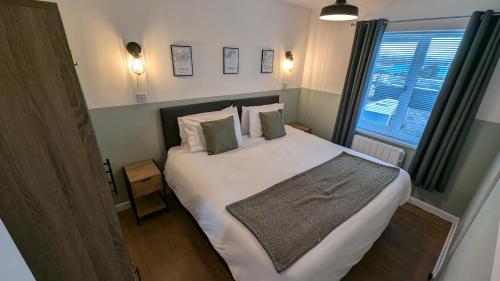 Un dormitorio con una gran cama blanca con ventana. en 2 Bedroom apartment in Brean, en Brean