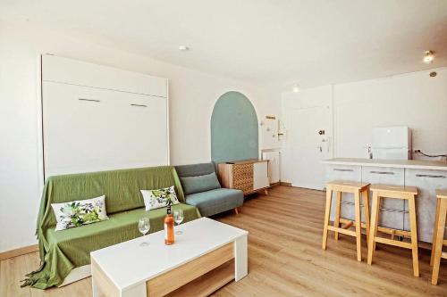 un salon avec un canapé et une table dans l'établissement Le Hyérois Studio, à Hyères