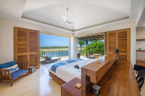 a bedroom with a bed and a view of the ocean at PH Condo Lago in El Encanto -Lake View Penthouse with Pool Punta Mita in Punta Mita