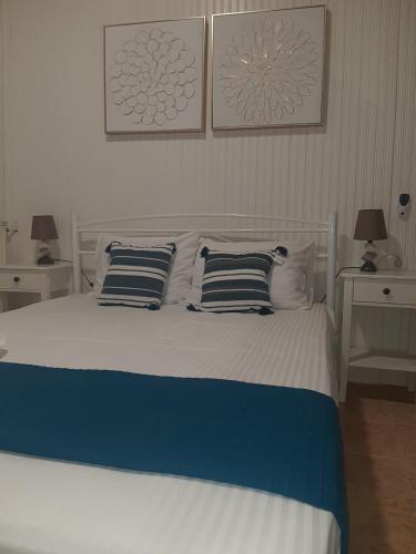 a bed with blue and white sheets and pillows at Boutique maison Filiatra in Filiatra