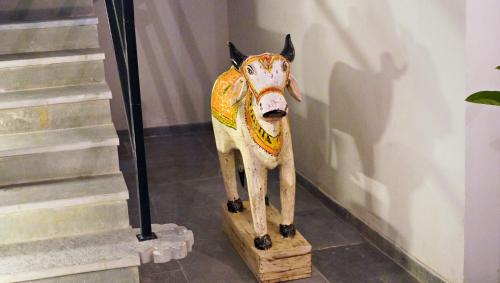 a statue of a cow on a wooden stand at Madri Retreat - Heritage Boutique Hotel with Pool in Udaipur