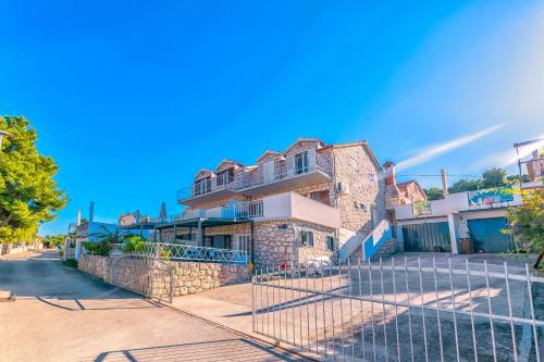 an old house with a fence in front of it at Apartments Terrace in Postira