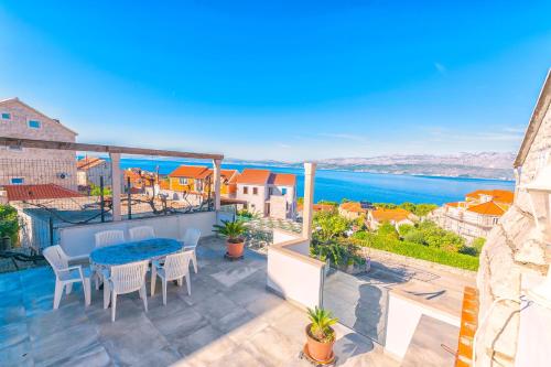 a balcony with a table and chairs and a view of the water at Apartments Terrace in Postira