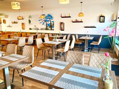 a restaurant with tables and chairs in a room at Hotel Wesselényi in Győr