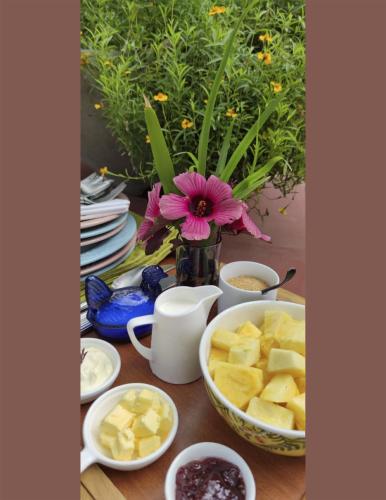 a table topped with bowls of food and a vase of flowers at Tierra Negra Suite in Pereira