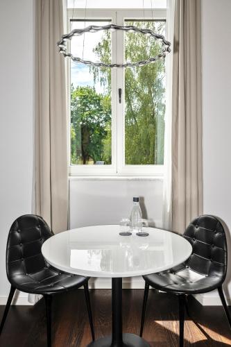 a white table and two chairs in front of a window at The Joseph in Vilnius