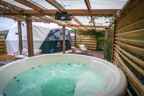 a bath tub in a backyard with a pergola at Hillside Haven - (Luxury Geodome) in Portpatrick