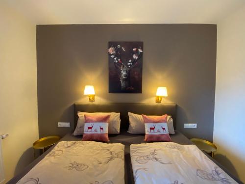 a bedroom with two beds and a painting on the wall at Sonnalm Panoramablick Garten Sauna in Rohrberg