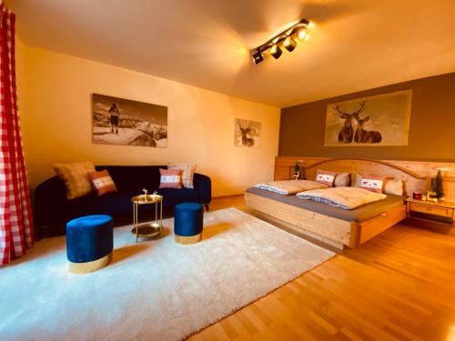 a living room with a bed and a couch at Sonnalm Panoramablick Garten Sauna in Rohrberg