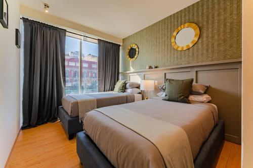 een hotelkamer met twee bedden en een raam bij Brick apartment two blocks from plaza Rio de Janeiro Roma in Mexico-Stad