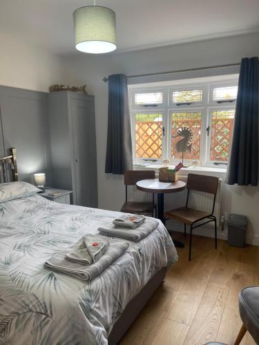una camera da letto con un letto, un tavolo e finestre di Godden Green B & B Guesthouse a Newchurch