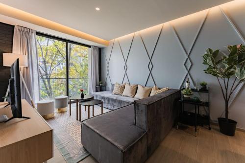 a living room with a couch and a tv at Elegant Apartment with Balcony and City Views in Mexico City