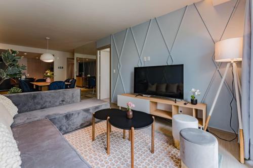 a living room with a couch and a tv at Elegant Apartment with Balcony and City Views in Mexico City