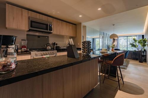 a kitchen with a counter and a stove top oven at Elegant Apartment with Balcony and City Views in Mexico City