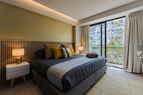 a bedroom with a large bed and a large window at Elegant Apartment with Balcony and City Views in Mexico City
