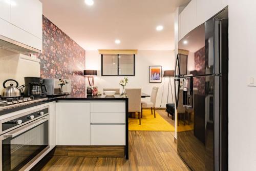 a kitchen with white cabinets and a dining room at Modern Apartment with Gym in La Condesa in Mexico City