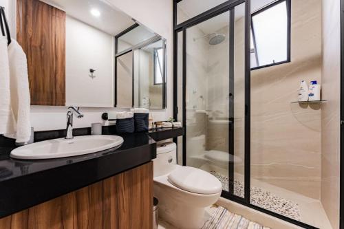 a bathroom with a toilet and a sink and a shower at Modern Apartment with Gym in La Condesa in Mexico City