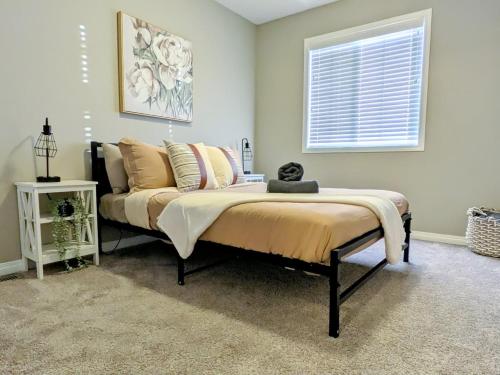 a bedroom with a bed with pillows and a window at A Slice Of Heaven In Airdrie By Eagleswingshomes1 in Airdrie