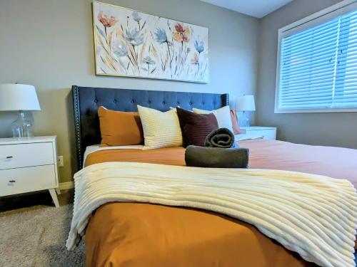 a bedroom with a bed with an orange bedspread at A Slice Of Heaven In Airdrie By Eagleswingshomes1 in Airdrie