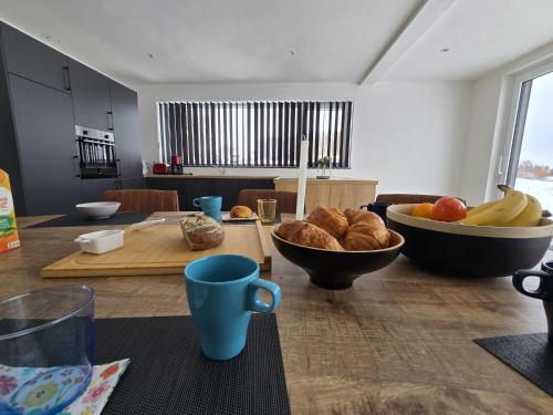 a kitchen with a table with bread and a bowl of fruit at La maison d'Achille in Nassogne