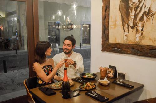 a man and a woman sitting at a table at Casa Lucia Hotel Boutique in Mérida