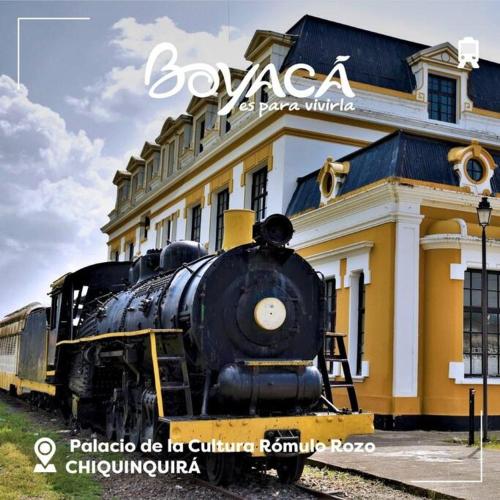 a train on the tracks in front of a building at Amplia Casa a 10 min de la Basílica - Chiquinquirá in Chiquinquirá