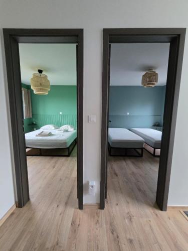 two mirrors in a room with two beds at La maison d'Achille in Nassogne