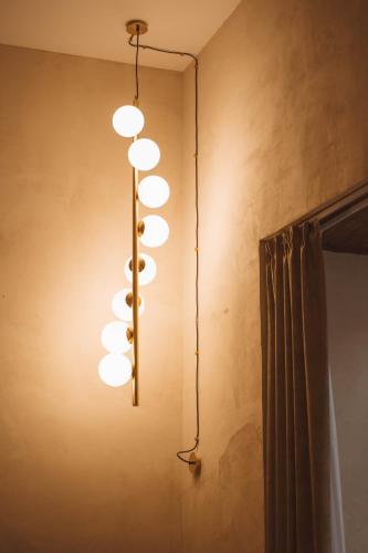 een rij lampen die aan een muur hangen bij Librai suite in Napels