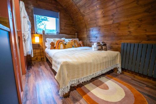 une chambre avec un lit dans une cabane en bois dans l'établissement Bonnie Brae - (Luxury Pod), à Portpatrick
