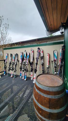 a bunch of skis leaning against a wall with a barrel at YAGHAN HOSTEL in Ushuaia