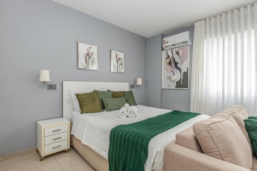 a bedroom with a large bed and a couch at Alphaville-Industrial com cozinha-piscina e academia-500mega in Barueri