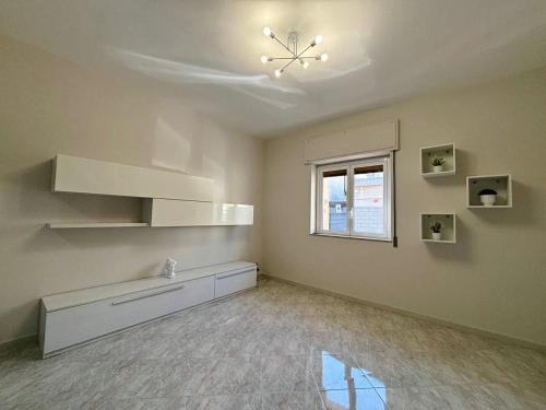 an empty room with a ceiling fan and a window at Dimora Rote in Acireale