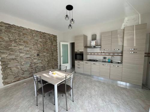 a kitchen with a table and chairs and a stone wall at Dimora Rote in Acireale