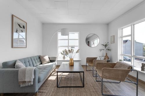 a living room with a couch and chairs and a table at Lovely & Spacious Apartments in Reykjavík