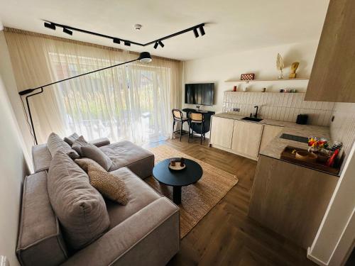 een woonkamer met een bank en een tafel bij Hill Apartment in Palanga