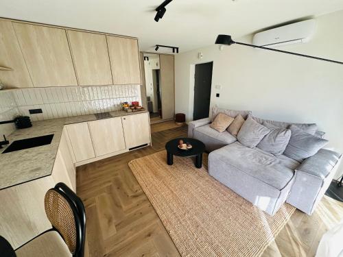 een woonkamer met een bank en een tafel bij Hill Apartment in Palanga