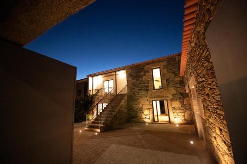 a stone house with stairs leading up to it at night at Casa de Trás-o-Muro in Vila Real