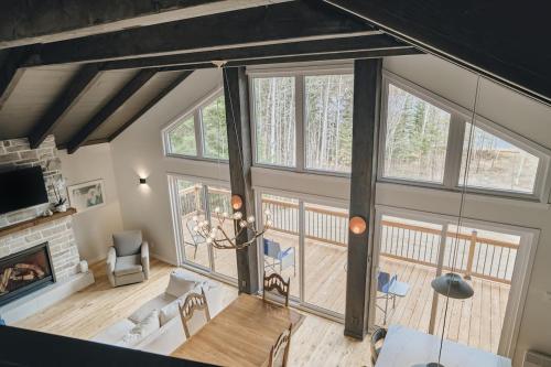 a living room with large windows and a fireplace at Cozy Chalet by the Lake - Your Perfect Escape in Hébertville
